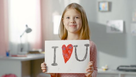 Cute Young Girl Shows Fun Drawing "I LOVE YOU" With Heart in the Middle. Shot on RED EPIC-W 8K Helium Cinema Camera.