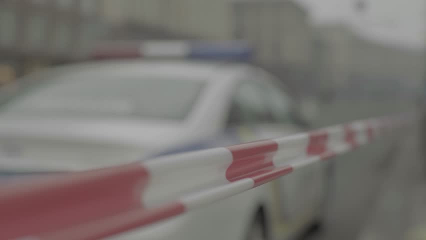 Police tape and a police car at the crime scene