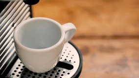 pour coffee with coffee maker in a white cup on a wooden table in the kitchen at the breakfast