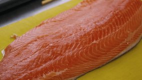 Cook cuts red fish into pieces, salmon, cooking. Close-up. 4k footage.
