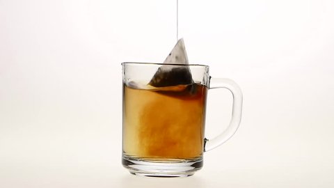 Pyramid tea bag in ?up with hot water, white background