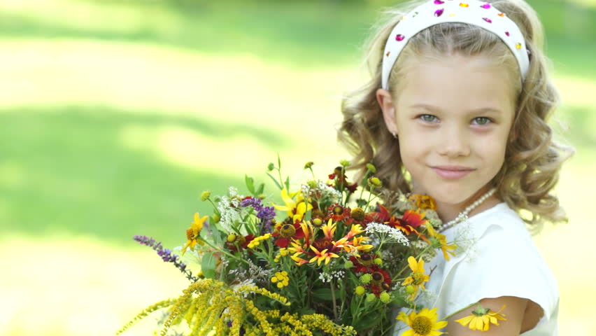 Closeup portrait of a girl with flowers looking at camera
