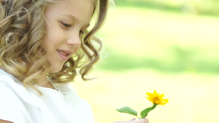 Portrait of a girl sniffing a flower field
