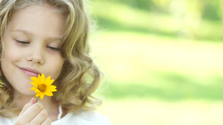 Closeup portrait of a girl with yellow flower
