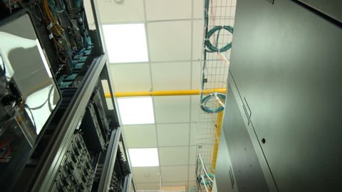 closeup camera moves from the lowest point along the data center storage with view of ceiling lamp and yellow pipe
