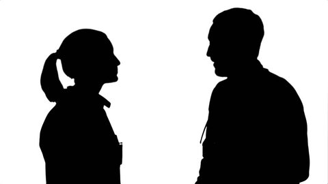 Silhouette Profile view of happy mature male and female doctors smiling while shaking hands.