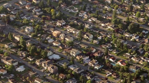 Aerial view from low-flying airplane of suburban neighborhood street and residential blocks