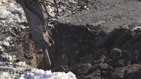 Breaker (hydraulic) cuts frozen soil. Timelapse stock footage video