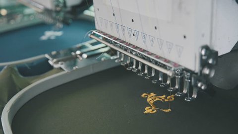 Embroidery machine on T-shirt in Textile Industry at Garment Manufacturers. Machine embroidery is embroidery process whereby sewing machine or embroidery machine is used to create patterns on textiles