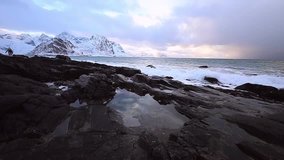 Ancient stones on the shores of cold Norwegian Sea at evening time. Lofoten islands. Beautiful Norway landscape. Slow Motion HD Footage.