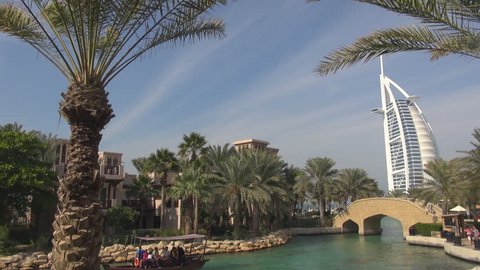 DUBAI, UAE - JANUARY 25, 2014, Touristic abra boat sail on exotic lake, famous Burj Al Arab hotel icon