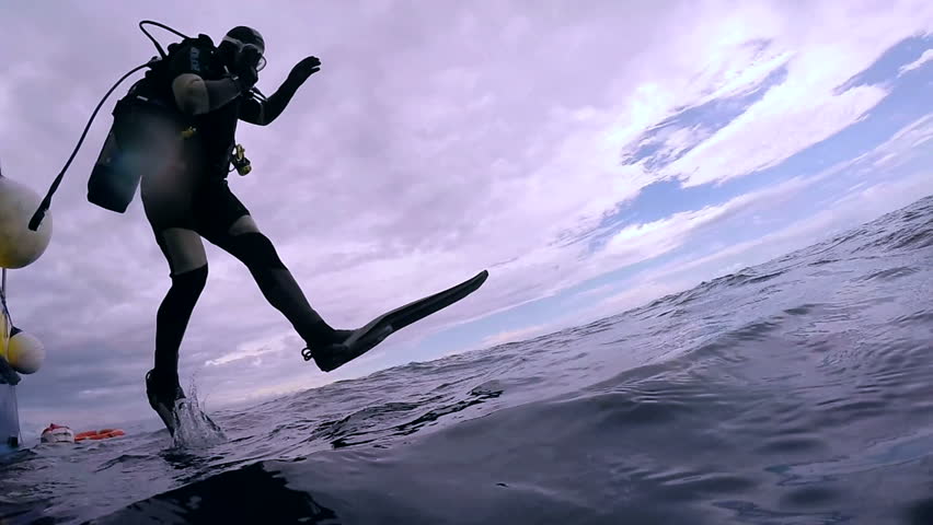 Scuba Diver Jumping into the Ocean. In slow motion a scuba diver jumps into water.  Scuba Diver Jumping Off Dive Boat. Royalty-Free Stock Footage #25565063