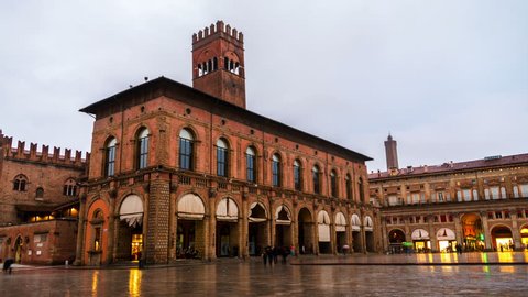 Bologna, Italy. King Enzo palace at the main square of Bologna, Italy. Famous landmark at sunset at night. Time-lapse during the rain