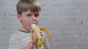 Cute little kid with ripe fresh banana, hd video