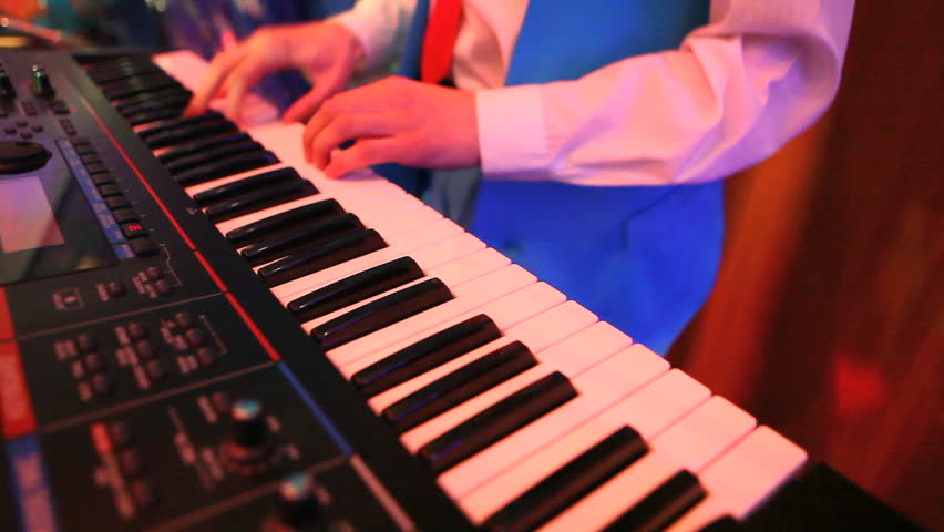 Male hands playing on piano at event