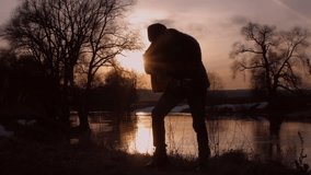 The man playing the guitar at sunset (silhouette)