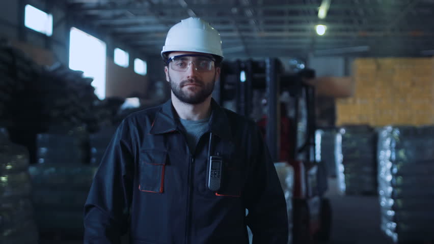 A male engineer walking in the warehouse and looking at camera. | Shutterstock HD Video #25591946