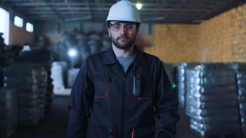 A male engineer walking in the warehouse and looking at camera. | Shutterstock HD Video #25592003