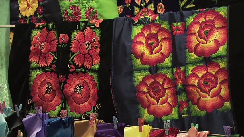 Display of Large Hand Crafted Mexican Blankets/Fabrics With a Multicolored Floral Print 2