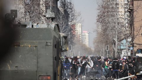 SANTIAGO, CHILE - AUGUST 9: Water cannon truck and riot police disperse demonstrators who burned a car during a student strike on August 9, 2011 in Santiago, Chile.
