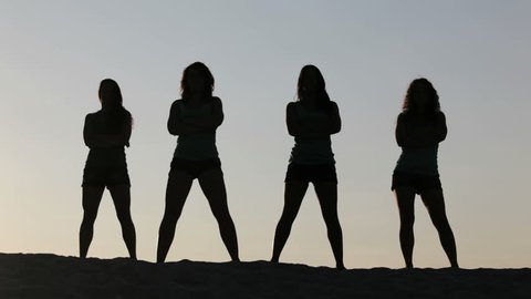 Carefree women dancing in the sunset on the beach