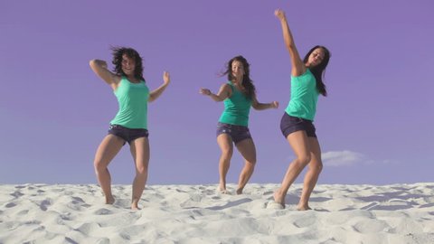 Beautiful women dancing on the sand together
