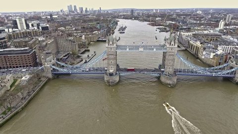 Aerial Shot of Flying Over Tower Bridge and River Thames in London, UK feat. Skyscrapers and Business Office Buildings in the Background with Boats and Car Transportation Vehicles in 4K Ultra HD