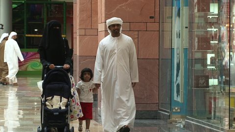 DUBAI, UAE - CIRCA 2008: View of an Emirati family, a couple with a little girl, walking together in the souq at Dubai Festival City Mall.