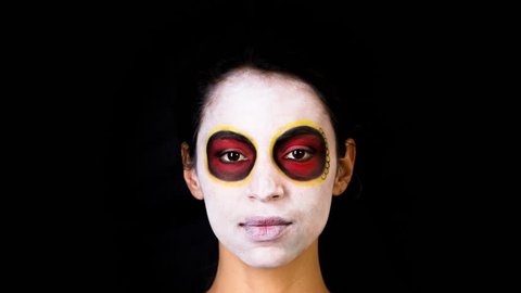 beautiful woman with custom designed candy skull mexican day of the dead face make up. this is a stop motion of the make up being applied to the face.