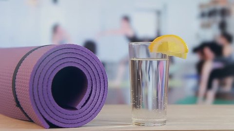 Yoga training, pilates, fitness mat, glass with water and lemon