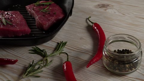 Beef fillet on a pan with pepper, rosemary, axe and garlic.