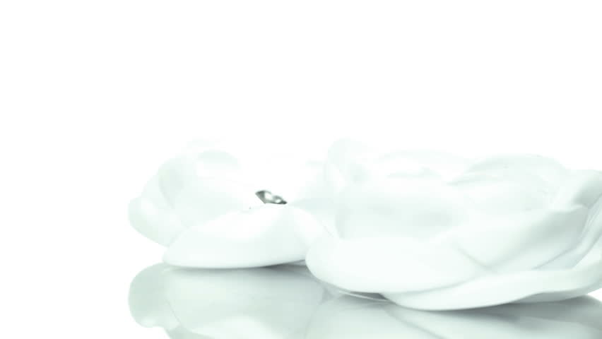 White flowers - fabric fashion accessories rotating slowly on white background, room for text above