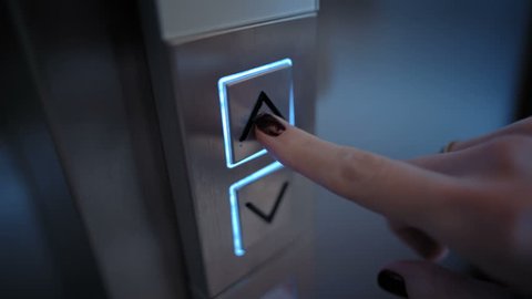 Young Woman Presses a Button of Lift to go Up by a Finger with a Painted Nail