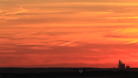 Passenger plane taking off runway in sunset