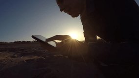 Man tablet. man holding a tablet, on the Internet web page flips through the silhouette of sunset - Powered by Shutterstock - Get 15% off with code: PIKWIZARD15