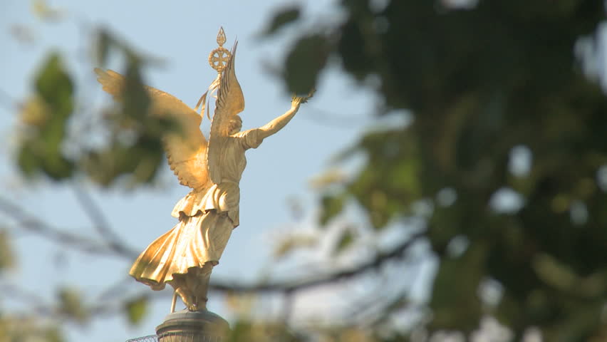 Angel of Victory behind some green leafs