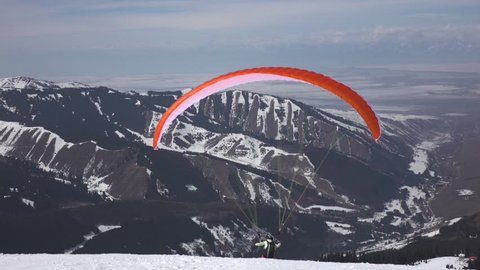 Paraglider take off against the backdrop of beautiful mountains
