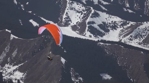 Flight of a tourist on a paraglider against the backdrop of beautiful mountains