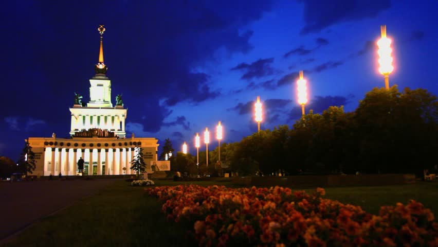 Flowerbed near exhibition hall number one at ENEA, people walk around

