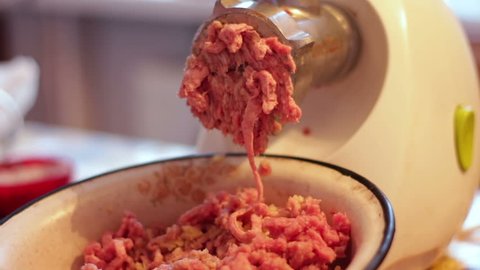 Putting minced meat and vegetable mixture through mincer at home.Cooking the meat forcemeat using the meat grinder,Butcher meat grinding using grinder mincer.