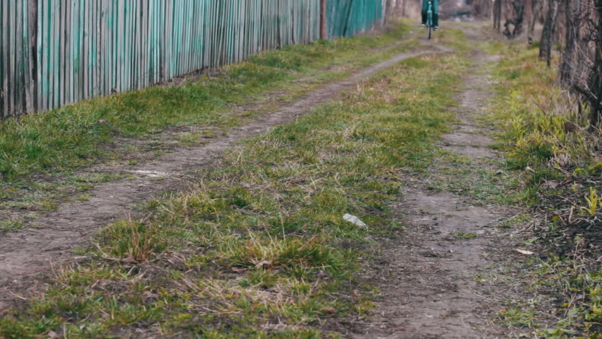A teenager rides through the village on an old vintage blue bike