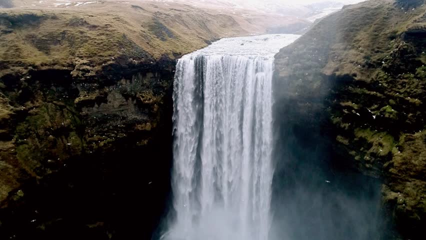 Aerial flight with drone over the famous  Skogar waterfall in Iceland. It is located on the South of the island. Image taken with action drone camera causing distortion and blur. Slow motion shot Royalty-Free Stock Footage #25673339