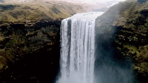 Aerial flight with drone over the famous  Skogar waterfall in Iceland. It is located on the South of the island. Image taken with action drone camera causing distortion and blur. Slow motion shot