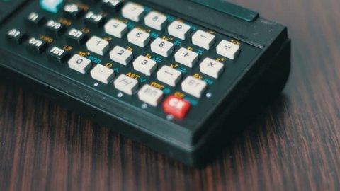Hand operates old retro calculator at workstation,Vintage engineering design.