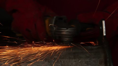 Worker cutting metal with a grinder. 