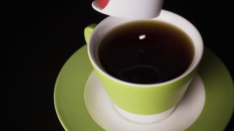 Slow motion. Sugar substitute, sweetener in tablets from the packaging drops into a cup of black tea