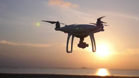 Quadcopter Drone Against Sunset at Beach