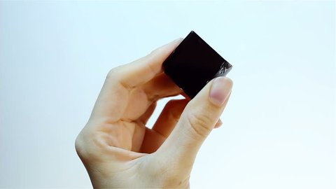 Obsidian is a naturally occurring volcanic glass. Specialist Gemologist Jeweler holding in hand black Obsidian - Sample of gemological set. Semiprecious gem for jewels, esoteric alternative medicine.