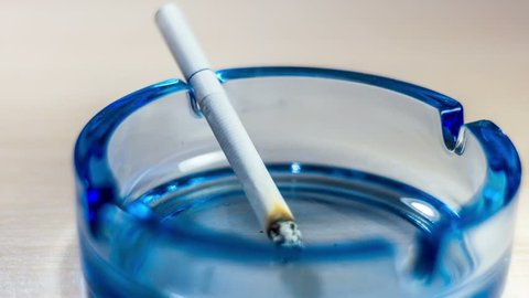 Burning cigarette in an ashtray time-lapse