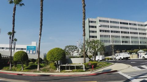 LONG BEACH CA/USA: February 16, 2016- A wide pan shot of the front exterior of Long Beach Memorial Hospital. Shot shows work trucks parked in front of entrance area.